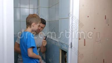 爸爸和儿子在家里一起修理，把厕所里的墙上的瓷砖去掉。